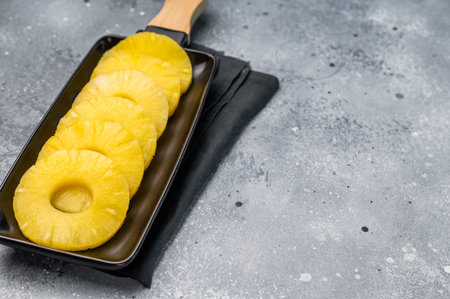 Pineapple rings slices on a board. grey background. top view.の写真素材