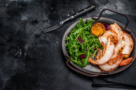 Grilled Jumbo Shrimps Prawns on a plate with salad. black background. top view.の写真素材