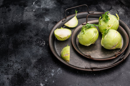 Raw kohlrabi on steel tray, Vegetable from Organic farm. black backround. top view.の写真素材