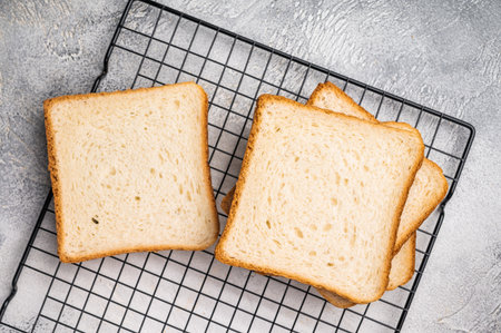 Square Slices of loaf wheat bread for toasts. white background. top view.の写真素材