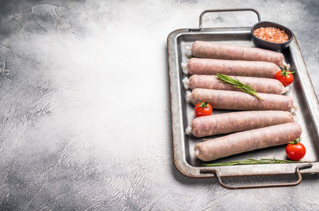 Fresh Sausages with minced pork and veal meat, wurst with herbs. grey background. top view.の写真素材