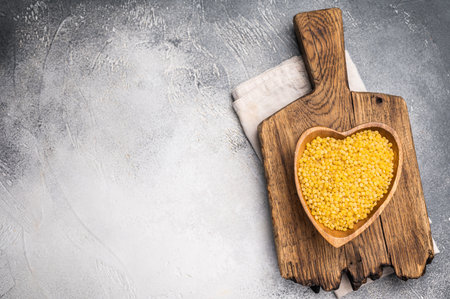 Dry Ptitim pasta, Israeli couscous in wooden bowl. white background. top view.の写真素材