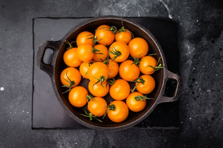 Fresh small yellow tomatoes, cherry tomatoes assortment, cocktail mix. black background. top view.の写真素材