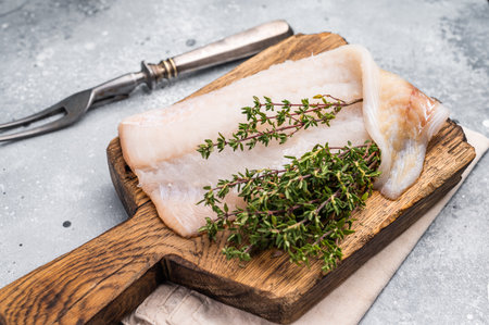 Fresh cod fish fillet, showcasing its delicate texture and pristine color, perfect for grilling or baking. grey background. top view.の写真素材