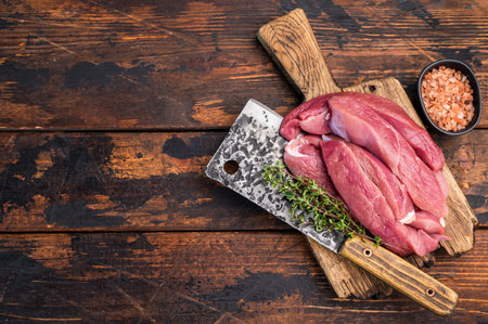 Duck breast fillet, raw sliced poultry meat on butcher board. wooden background. top view.の写真素材