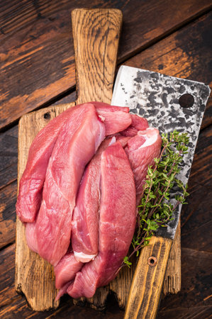 Duck breast fillet, raw sliced poultry meat on butcher board. wooden background. top view.の写真素材