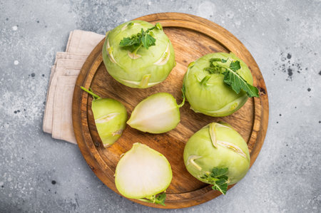 Raw kohlrabi sliced on pieces on wooden tray. grey backround. top view.の写真素材