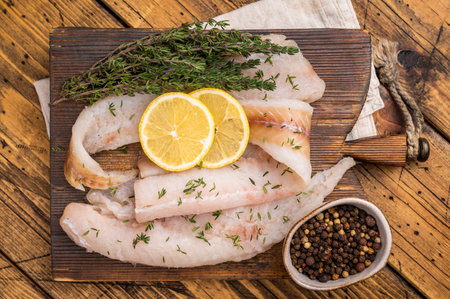 Haddock sea fish fillets, raw whitefish on a wooden board ready for cooking. wooden background. top...