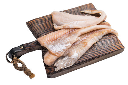 Raw Pollock fish fillets on a wooden board isolated on white background. top view.