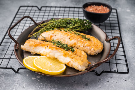 Baked Cod fish fiilet, fried whitefish meat. Grey background. top view.