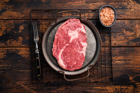 Prime Rib eye steak in a tray, raw dry aged beef meat on wooden background. top view.の写真素材