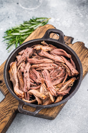 Savory pulled beef brisket served in a skillet, dipping creating an appealing and mouthwatering...
