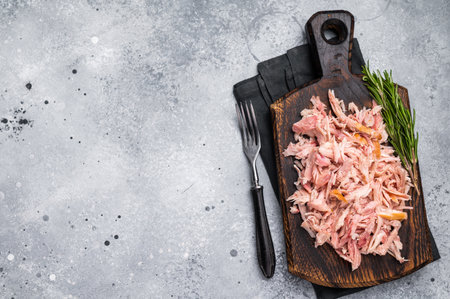Shredded or Pulled Chicken meat on wooden board. grey background. top view.