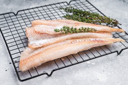 Raw pollock white fish fillet. grey background. top view.