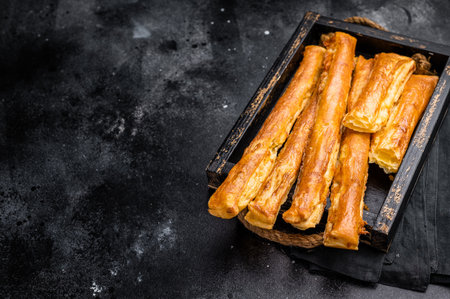 Bread sticks with cheese and salt. black background. top view.