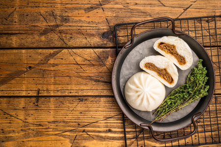 Chinese Bao Baozi steam bun with meat on steel tray. wooden background. top view.