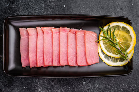Premium quality tuna sashimi, expertly cut for maximum tenderness and taste, perfect for sushi enthusiasts. black background. top view.の写真素材