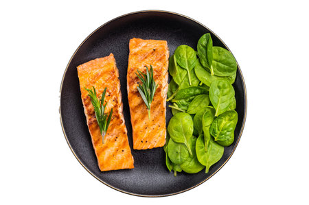 Grilled salmon fillet with spinach, fish steak in a plate isolated on white background. top view.の写真素材