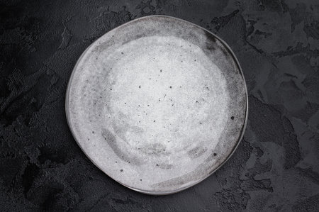 Gray matte plate overhead on dark background. Premium empty tableware with dramatic contrastの写真素材
