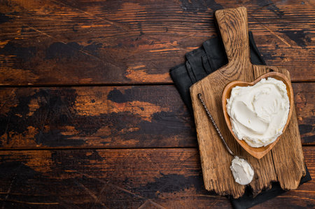 Traditional Mascarpone cheese in wooden bowl. Wooden background. Top view.の写真素材