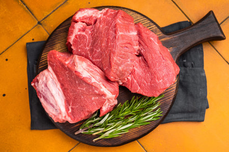 Raw beef fillet tender steaks on a decorative wooden board, fresh meat ready for grill. top view.