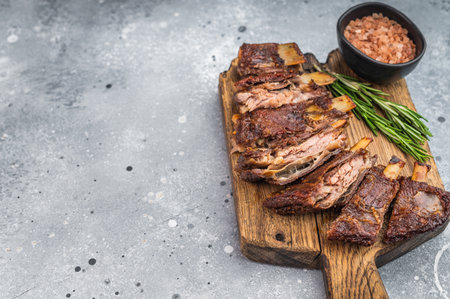Barbecue lamb ribs portions with roasted surface on wooden board light background restaurant style foodの写真素材