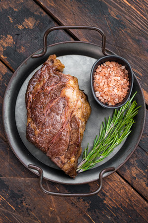 Seared beef chuck eye steak in metal pan with rosemary and salt. Tender cooked beef meat top view.の写真素材