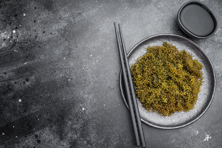 Seaweed salad with chopsticks and soy sauce on dark backgroundの写真素材