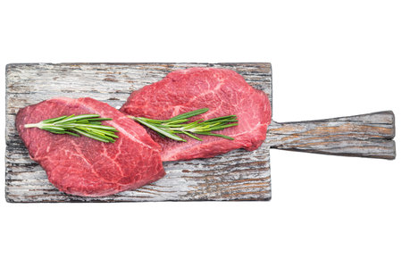 Raw top blade steaks with rosemary on rustic wooden board over bright white background perfect for gourmet butcher and culinary stock imagesの写真素材