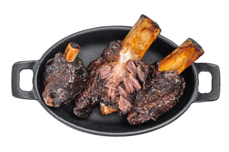 Braised beef ribs with pulled texture and caramelized surface in skillet. Slow cooked beef ribs with...