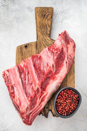 Raw fresh beef ribs on cutting board with peppercorns, top viewの写真素材