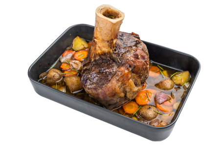 Slow cooked veal shank ossobuco style roasted with vegetables and gravy in baking tray on light background.の写真素材