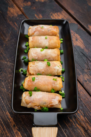 Fried spring rolls Lumpia crunchy appetizer with soy sauce and scallions minimal Asian food concept.