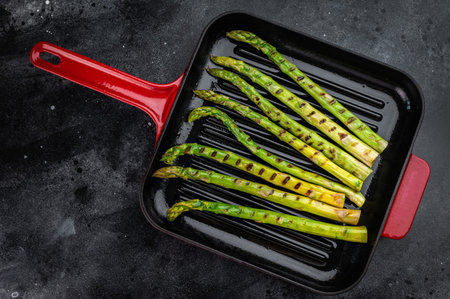Healthy grilled asparagus cooking in ribbed pan, clean food photography with copy space, vegan gourmet vegetable preparation concept.の写真素材
