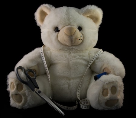 white teddy with sewing tools, needles,siccors and rulerの写真素材