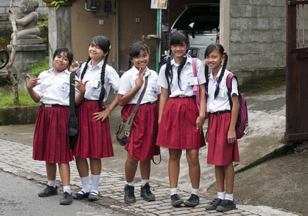 UBUD - 5 April 2011: Young school girls in uniform on the stret having fun on April 5, 2011 on Ubud street on Bali, Indonesia	 のeditorial素材