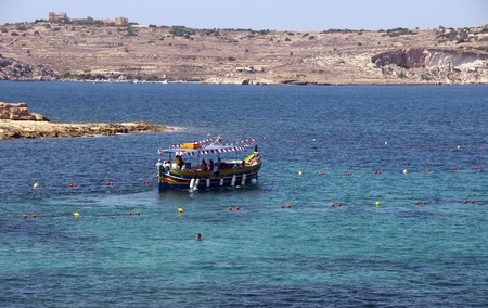 small boat with people on a harbour cruise on Maltaの写真素材
