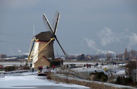 people skating in front of windmill Hollandの写真素材