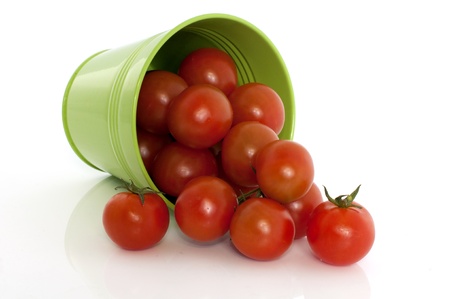 isolated red tomatoes in green basketの写真素材