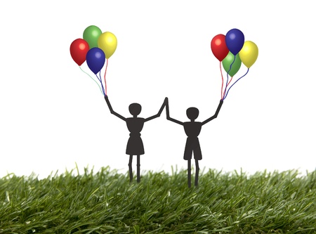 children happy playing with balloons outside in the grassの写真素材
