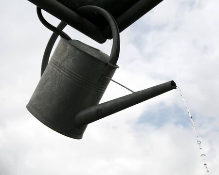 metal watering can flowing waterの写真素材