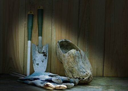 garden tools gloves and wooden shoe on a wooden shelfの写真素材