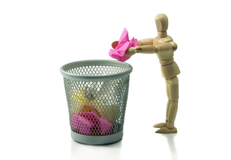 wooden puppet throw crumpled paper in trash canの写真素材