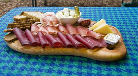 Switch plate with cheese and meat on a blue dressed tableの写真素材