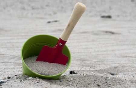 red and green shovel and bucket on the beachの写真素材