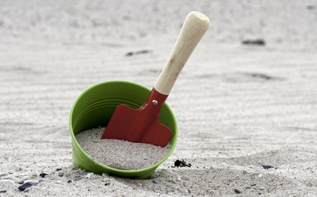 red and green shovel and bucket on the beachの写真素材