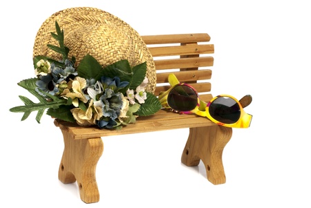 brown wooden stool with old hat and yellow children sunglassesの写真素材