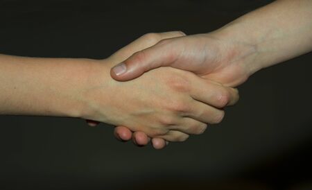 two friends shake hands making a dealの写真素材