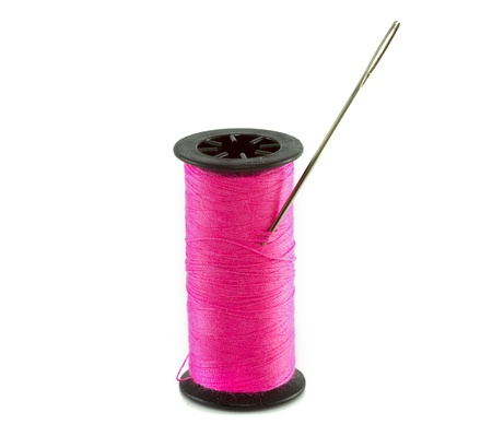 pink thread with needle isolated on whiteの写真素材