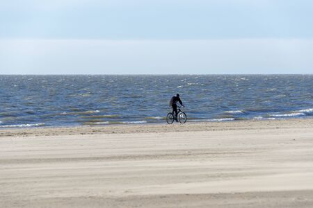 man on bike on the beachの写真素材